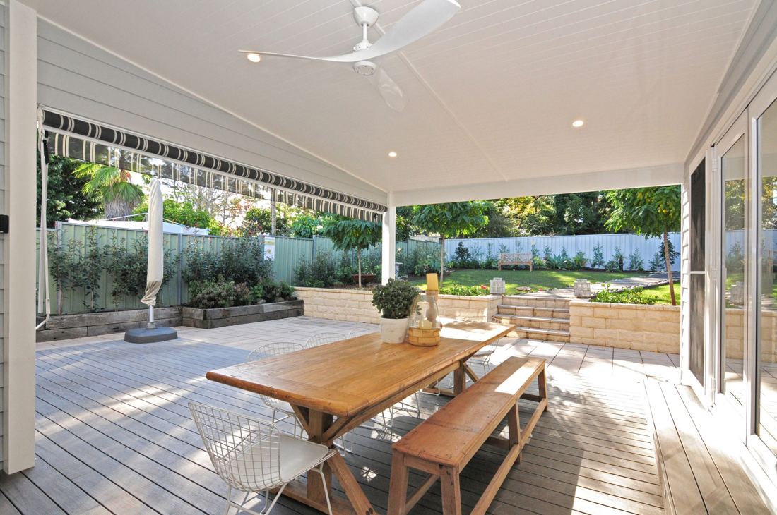 Covered outdoor dining area with a timber table